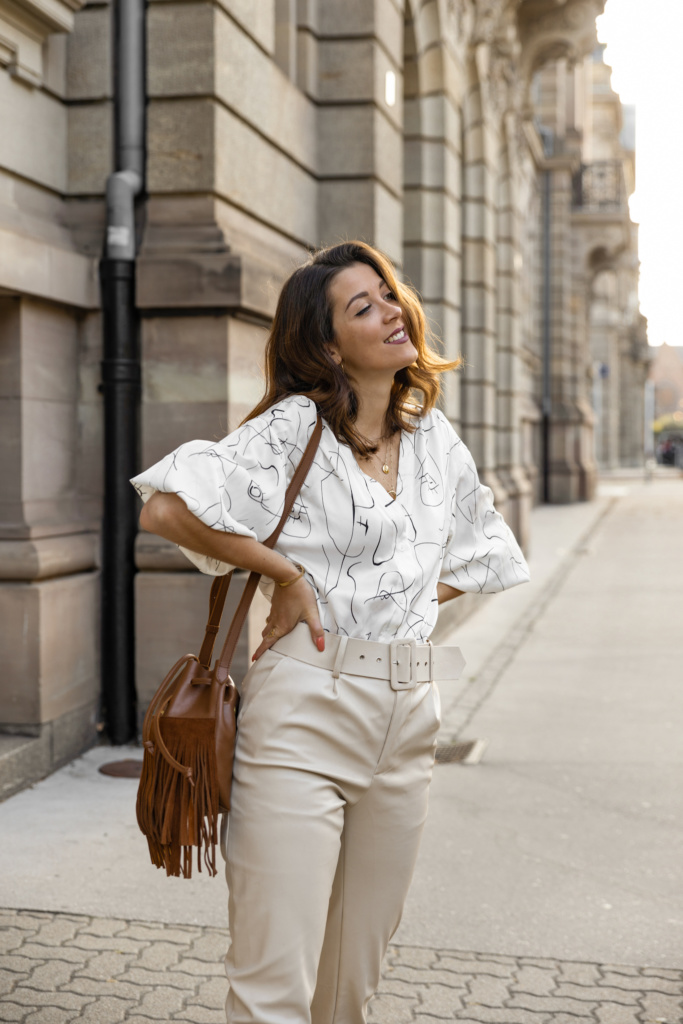 Look d'automne blouse à motif, pantalon cuir et sac à franges